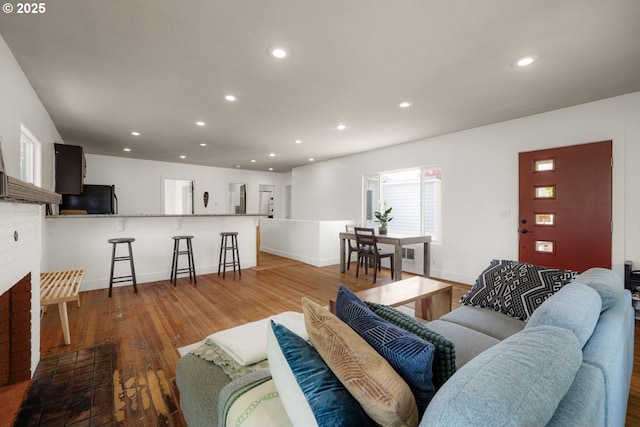 living room featuring baseboards, recessed lighting, and wood finished floors