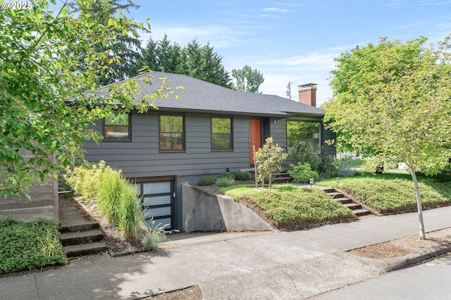6833 NE 18th Ave, Portland, OR 97211 - view of front of property with a garage, driveway, a chimney, and a shingled roof