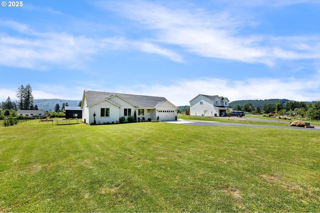 26815 NE Yacolt Rd, Yacolt, WA 98675 - view of front of home with board and batten siding, asphalt driveway, an attached garage, a front lawn, and a mountain view