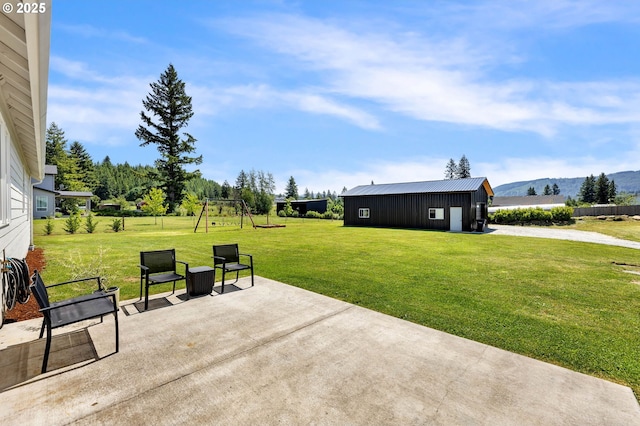 26815 NE Yacolt Rd, Yacolt, WA 98675 - view of patio / terrace featuring a mountain view, a playground, an outdoor structure, and a pole building