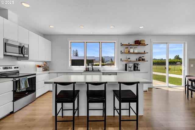 26815 NE Yacolt Rd, Yacolt, WA 98675 - kitchen with stainless steel appliances, a kitchen bar, recessed lighting, and plenty of natural light