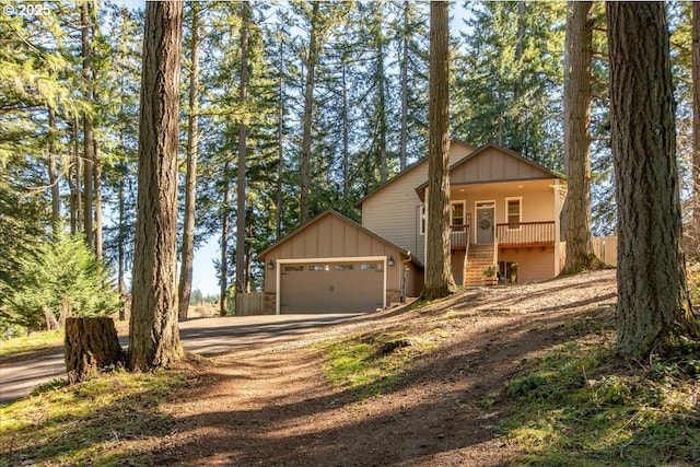 13135 SE Winston Rd, Damascus, OR 97089 - rustic home with board and batten siding, an attached garage, driveway, stairway, and a porch