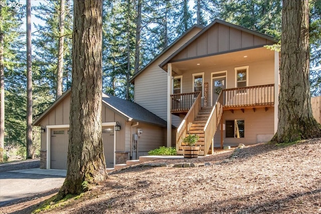 13135 SE Winston Rd, Damascus, OR 97089 - chalet / cabin with aphalt driveway, a garage, board and batten siding, a porch, and stairway