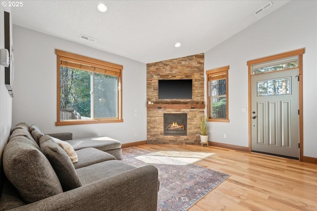 13135 SE Winston Rd, Damascus, OR 97089 - living area featuring visible vents, lofted ceiling, a stone fireplace, and wood finished floors