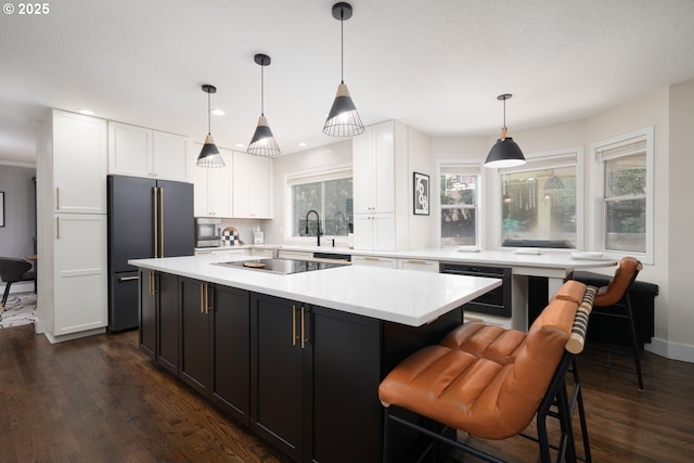 16223 SW 146th Ave, Portland, OR 97224 - kitchen with high end refrigerator, dark wood finished floors, light countertops, white cabinets, and black electric cooktop
