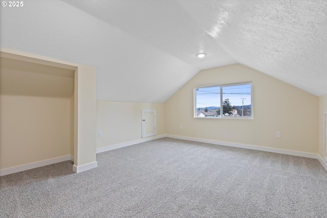 412 Monmouth Ave S, Monmouth, OR 97361 - additional living space featuring carpet floors, baseboards, vaulted ceiling, and a textured ceiling