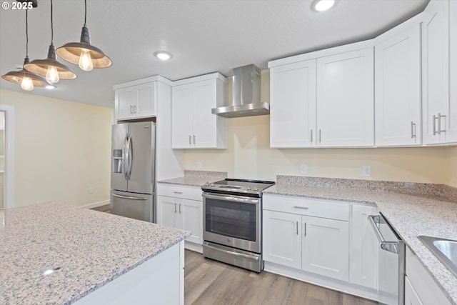 412 Monmouth Ave S, Monmouth, OR 97361 - kitchen featuring appliances with stainless steel finishes, white cabinets, decorative light fixtures, and wall chimney exhaust hood