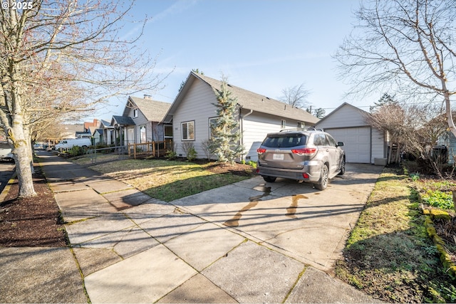 view of side of home with a garage, driveway, an outdoor structure, and fence