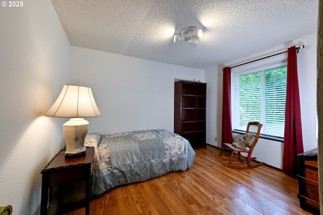 bedroom with wood finished floors and a textured ceiling