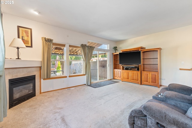 carpeted living room featuring a tile fireplace