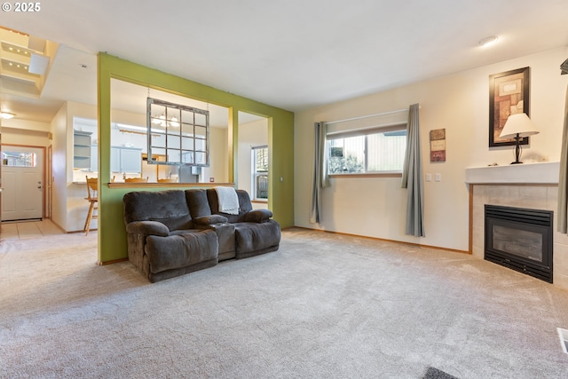 carpeted living room with a tile fireplace