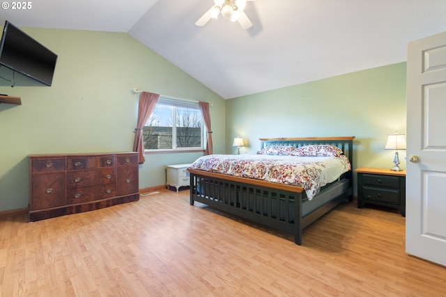 bedroom with ceiling fan, lofted ceiling, and light hardwood / wood-style flooring