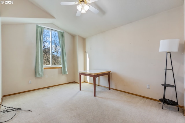 interior space with vaulted ceiling, light colored carpet, and ceiling fan