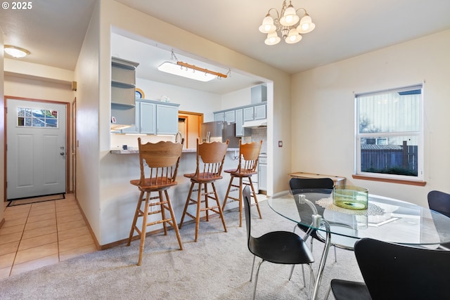 dining room with light tile patterned flooring and a notable chandelier