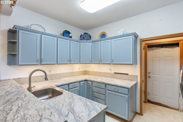 kitchen with sink, kitchen peninsula, and blue cabinets