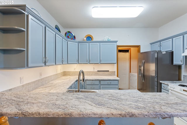 kitchen featuring white electric stove, sink, stainless steel fridge, and kitchen peninsula