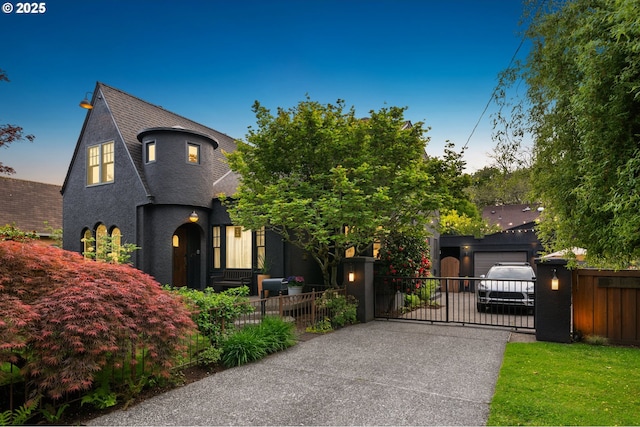view of front of home with driveway, a gate, a garage, fence, and stucco siding