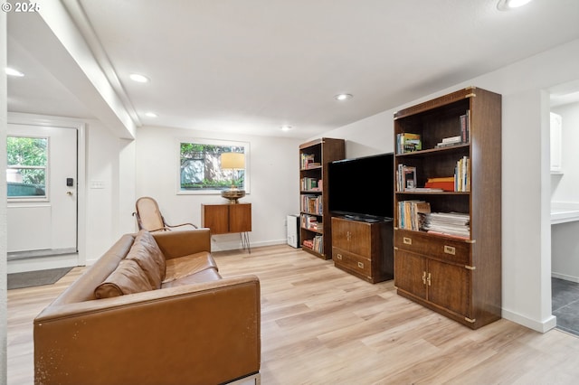 living area featuring recessed lighting, baseboards, and light wood-type flooring