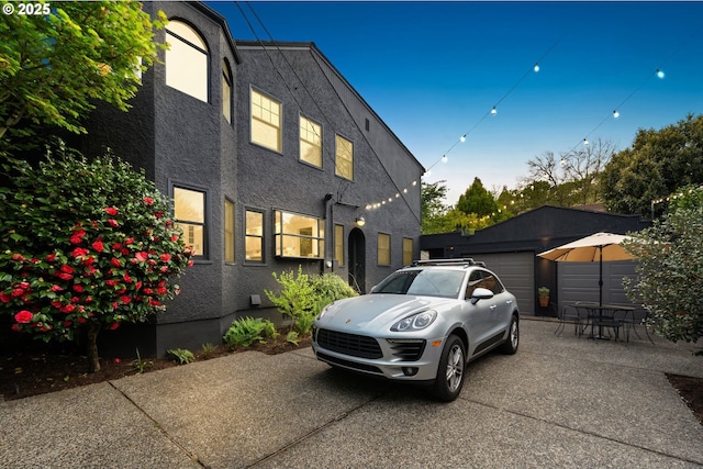view of property exterior featuring an attached garage, driveway, and stucco siding