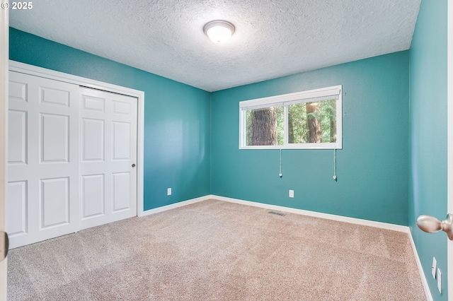 4718 SW Miles Ct, Portland, OR 97219 - unfurnished bedroom featuring carpet flooring, a textured ceiling, baseboards, and a closet
