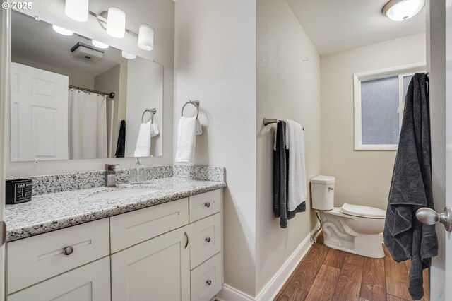4718 SW Miles Ct, Portland, OR 97219 - bathroom with wood finished floors, toilet, baseboards, and vanity