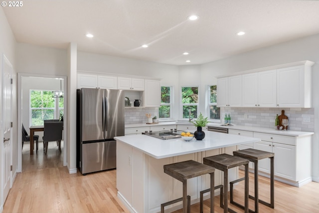 15530 SW Brighton Ct, Beaverton, OR 97007 - kitchen with freestanding refrigerator, backsplash, white cabinets, light wood-style floors, and recessed lighting
