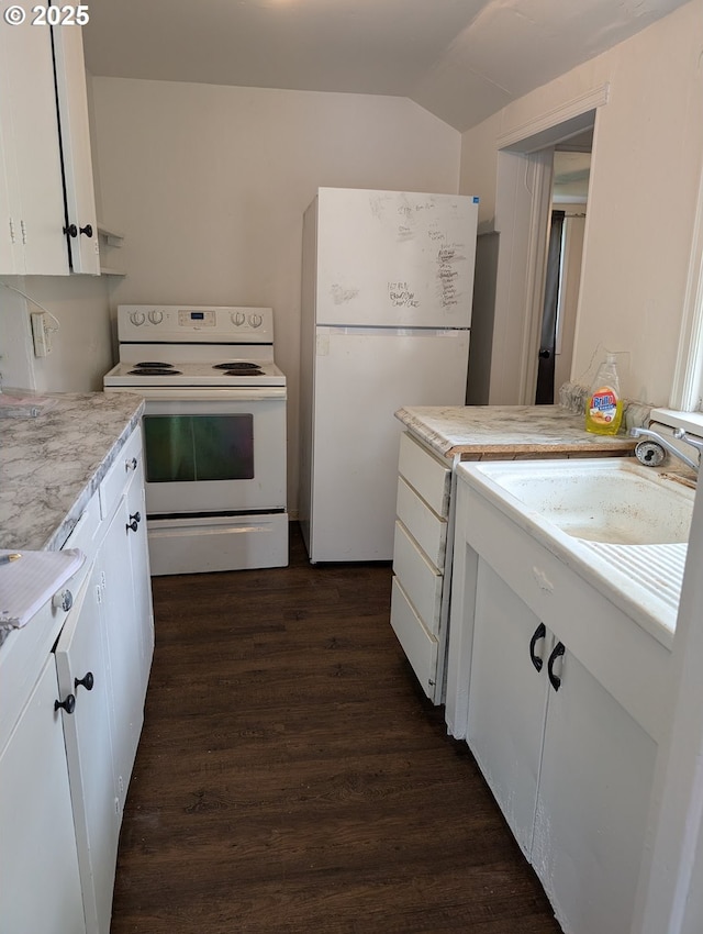 kitchen with white appliances, dark wood-style floors, white cabinets, light countertops, and vaulted ceiling
