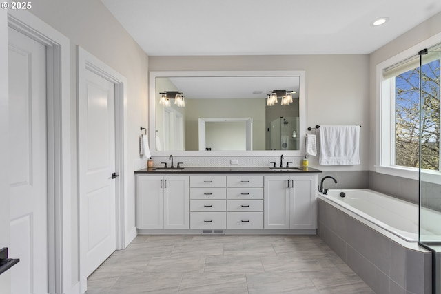 6621 NW Lolo Ter, Portland, OR 97229 - bathroom featuring double vanity, a shower stall, a bath, and recessed lighting