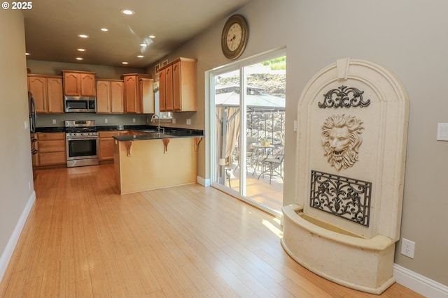 1680 NW Avery St, Roseburg, OR 97471 - kitchen featuring appliances with stainless steel finishes, recessed lighting, a sink, light wood-style floors, and a breakfast bar area