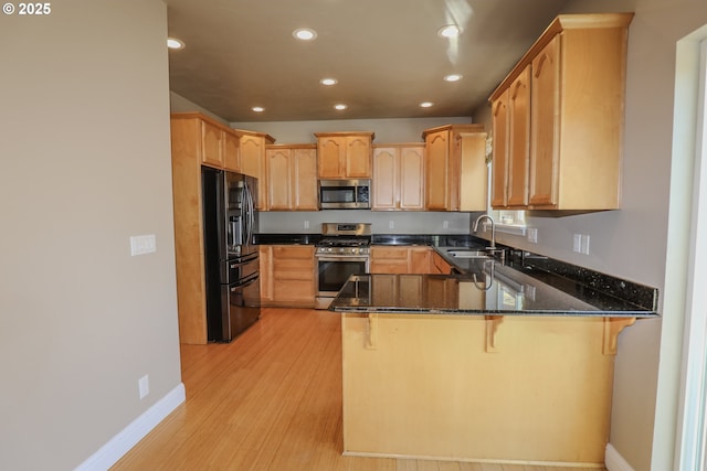 1680 NW Avery St, Roseburg, OR 97471 - kitchen with appliances with stainless steel finishes, a peninsula, a sink, recessed lighting, and dark stone countertops