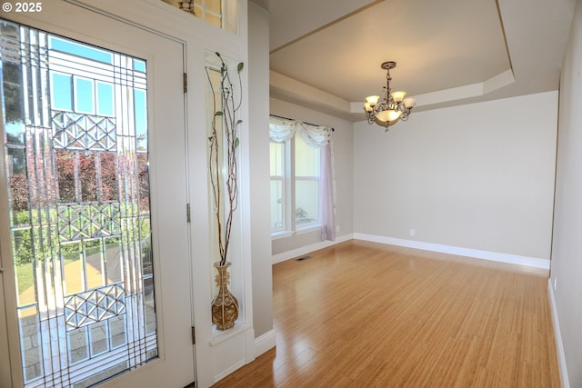 1680 NW Avery St, Roseburg, OR 97471 - doorway featuring a chandelier, baseboards, a tray ceiling, and wood finished floors