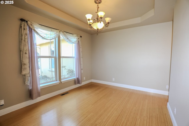 1680 NW Avery St, Roseburg, OR 97471 - empty room featuring a raised ceiling, light wood-style floors, baseboards, and a chandelier
