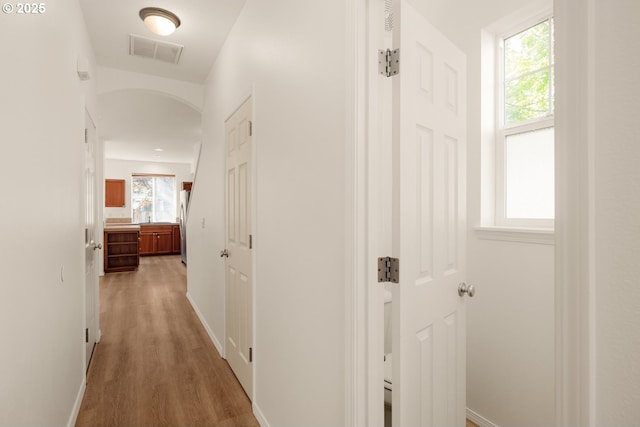 17246 SW Pleasanton Ln, Beaverton, OR 97003 - hall featuring light wood finished floors, arched walkways, and baseboards