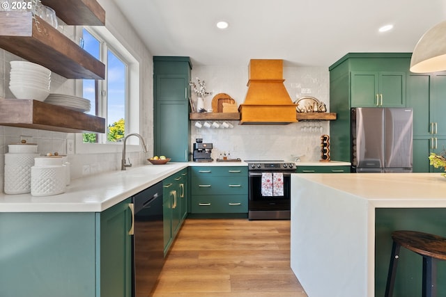 kitchen with open shelves, a sink, appliances with stainless steel finishes, and green cabinets