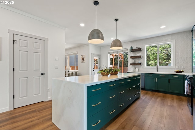kitchen featuring dark wood-style flooring, green cabinetry, light countertops, a center island, and recessed lighting