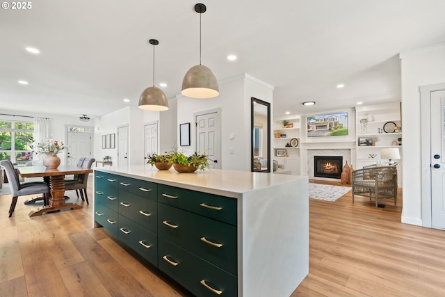 kitchen featuring a fireplace, light wood-style floors, recessed lighting, a center island, and green cabinets