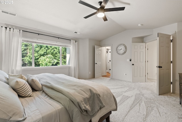 bedroom featuring a ceiling fan, visible vents, light carpet, and lofted ceiling