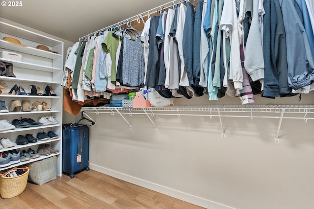 walk in closet with wood finished floors
