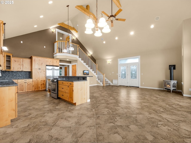 kitchen featuring light brown cabinets, stainless steel appliances, open floor plan, hanging light fixtures, and glass insert cabinets