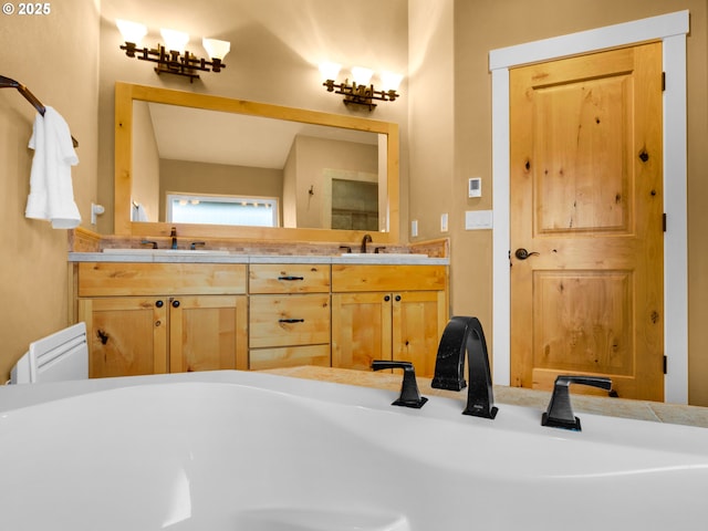 bathroom with double vanity, a freestanding tub, and a sink