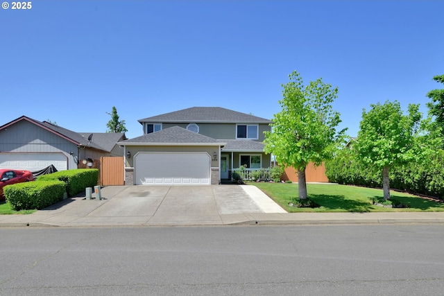 traditional-style house with concrete driveway, an attached garage, a front lawn, and a shingled roof