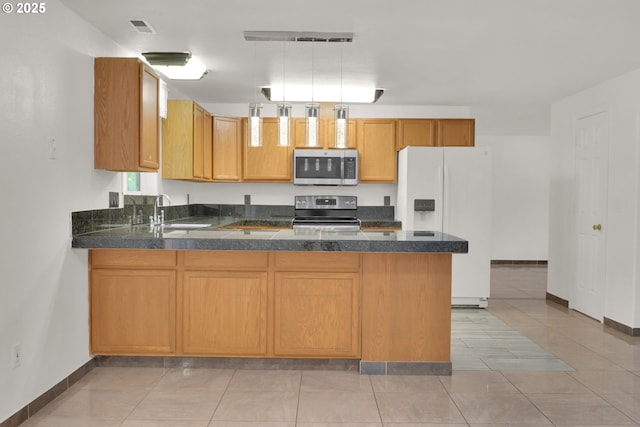 kitchen with a sink, a peninsula, stainless steel appliances, baseboards, and dark countertops