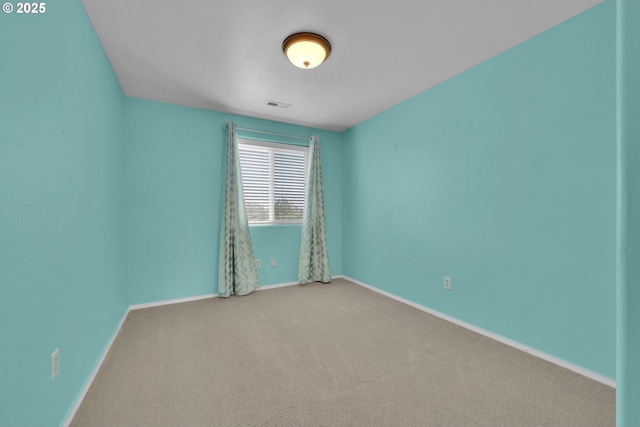 empty room with baseboards, visible vents, and carpet