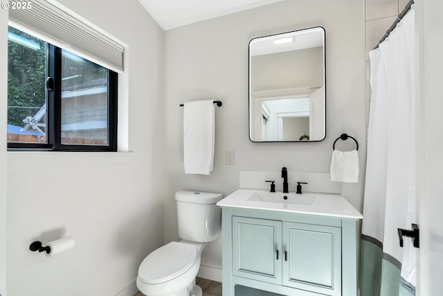 full bath featuring toilet, vanity, and baseboards