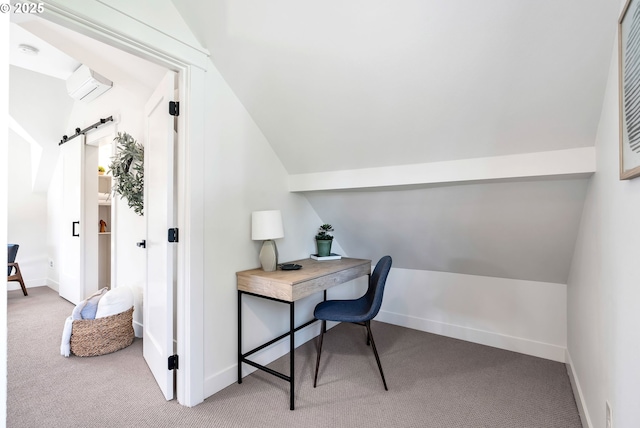carpeted office featuring vaulted ceiling, a barn door, baseboards, and a wall mounted air conditioner