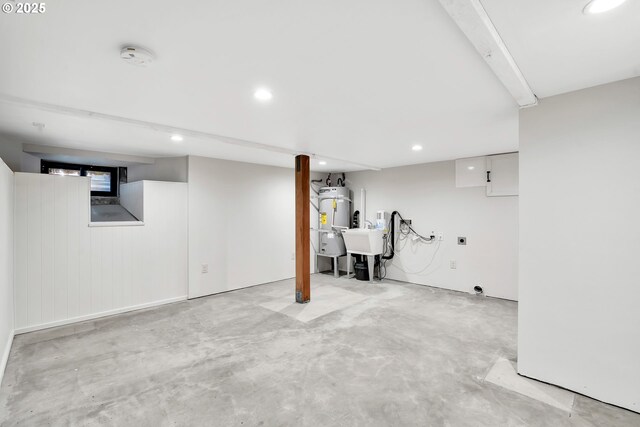 basement featuring water heater, recessed lighting, and a sink