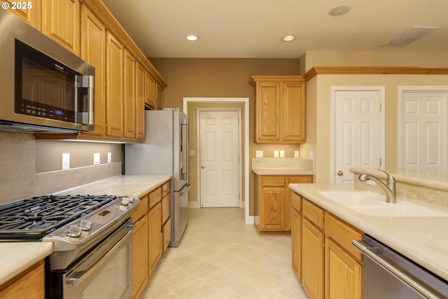 kitchen with stainless steel appliances, light countertops, a sink, and visible vents