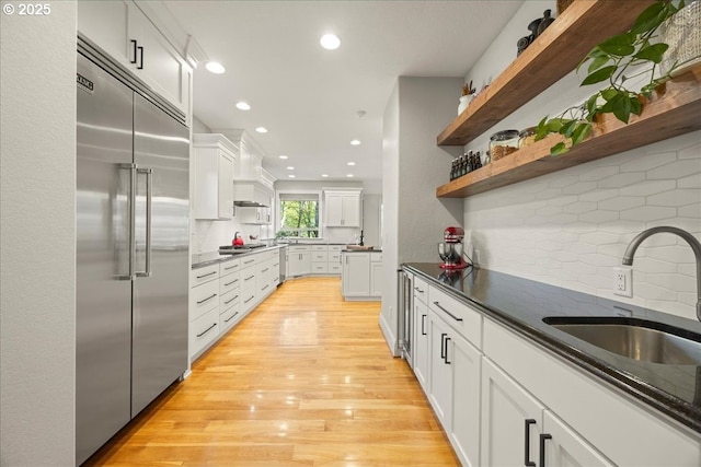 9522 NW Skyview Dr, Portland, OR 97231 - kitchen featuring appliances with stainless steel finishes, open shelves, a sink, tasteful backsplash, and recessed lighting