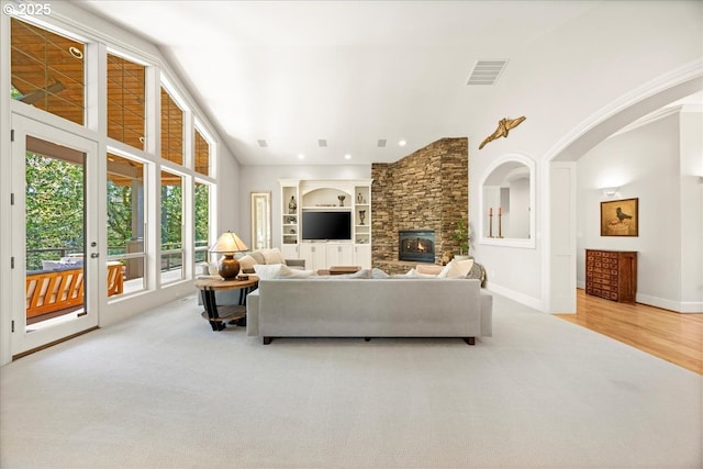 9522 NW Skyview Dr, Portland, OR 97231 - carpeted living room with a stone fireplace, baseboards, built in shelves, and a high ceiling