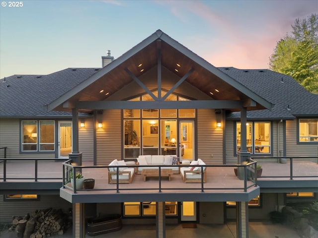 9522 NW Skyview Dr, Portland, OR 97231 - back of property at dusk with an outdoor living space, a wooden deck, a chimney, and a shingled roof